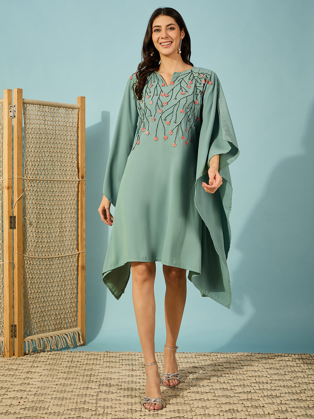 Stand out at any party in this stylish green kaftan dress with embroidered bead details and flowers.
