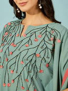 Celebrate in elegance with this green embroidered kaftan dress, featuring pink floral accents.
