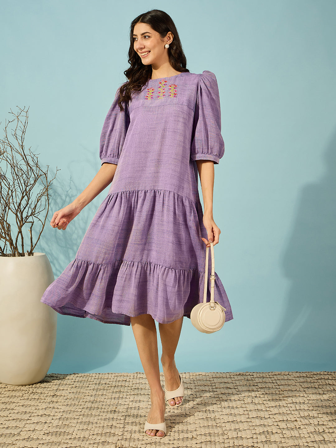 Stylish purple linen mini dress with hand-embroidered detailing and puffed sleeves for a playful touch.
