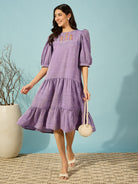 Stylish purple linen mini dress with hand-embroidered detailing and puffed sleeves for a playful touch.
