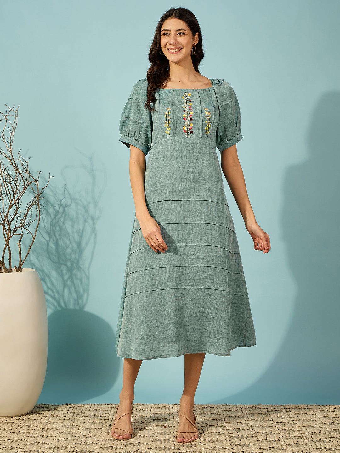 Elegant green midi dress with floral embroidery and pin tuck detailing, perfect for any occasion.

