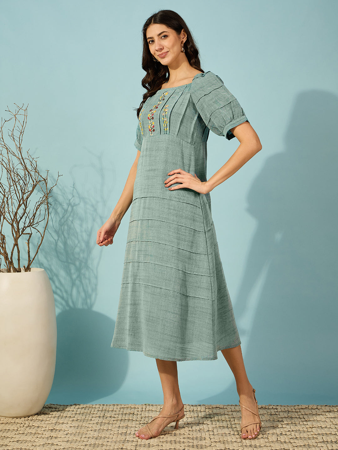Chic green floral-embroidered midi dress with intricate pin tucks, designed for effortless elegance.
