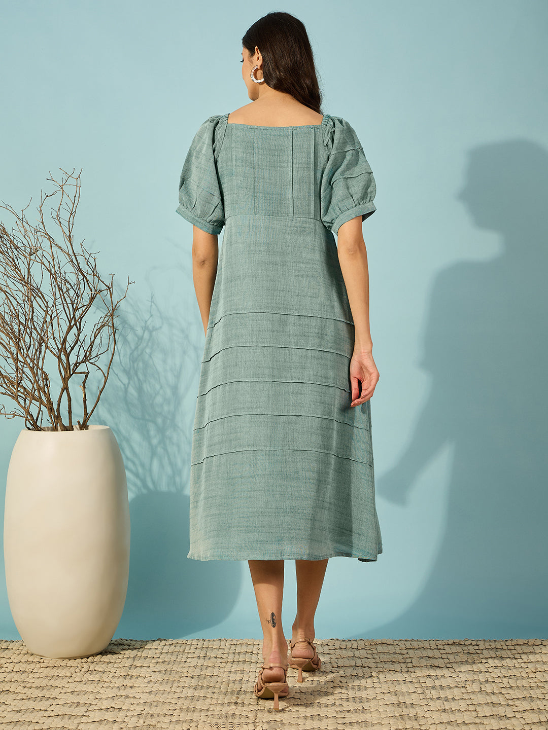 A stylish green midi dress with floral embroidery, designed for a flattering slim fit and refined elegance.
