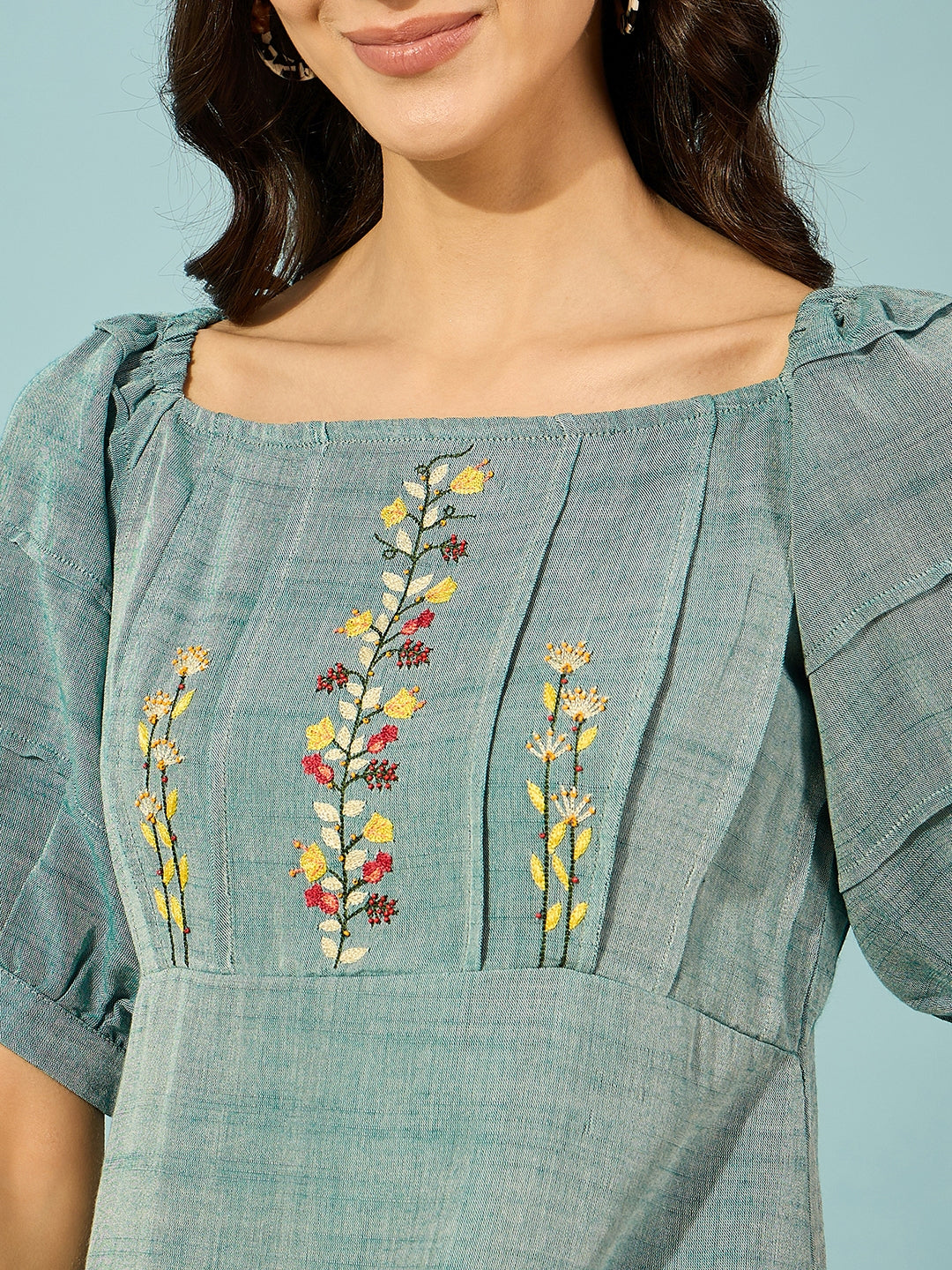 Floral-embroidered green midi dress in soft viscose linen, offering timeless elegance and comfort.
