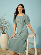 Green viscose linen midi dress with delicate floral embroidery, ideal for both casual and formal events.
