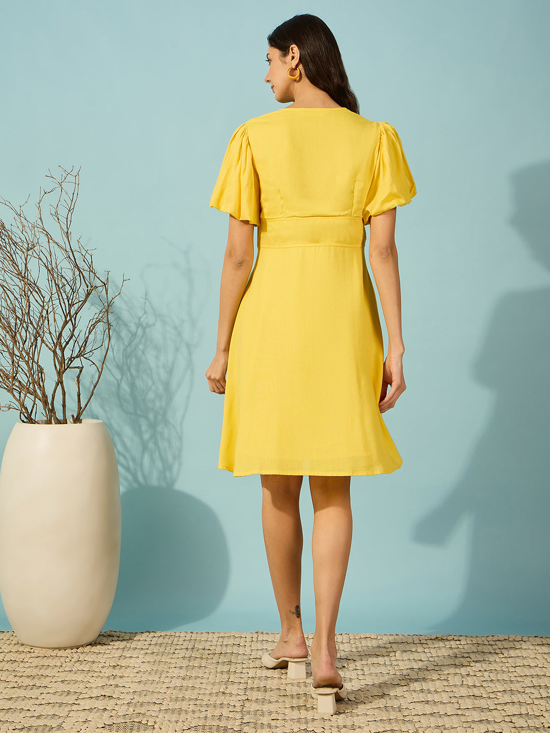Elegant women's knee-length yellow dress featuring intricate hand embroidery and soft viscose linen fabric.
