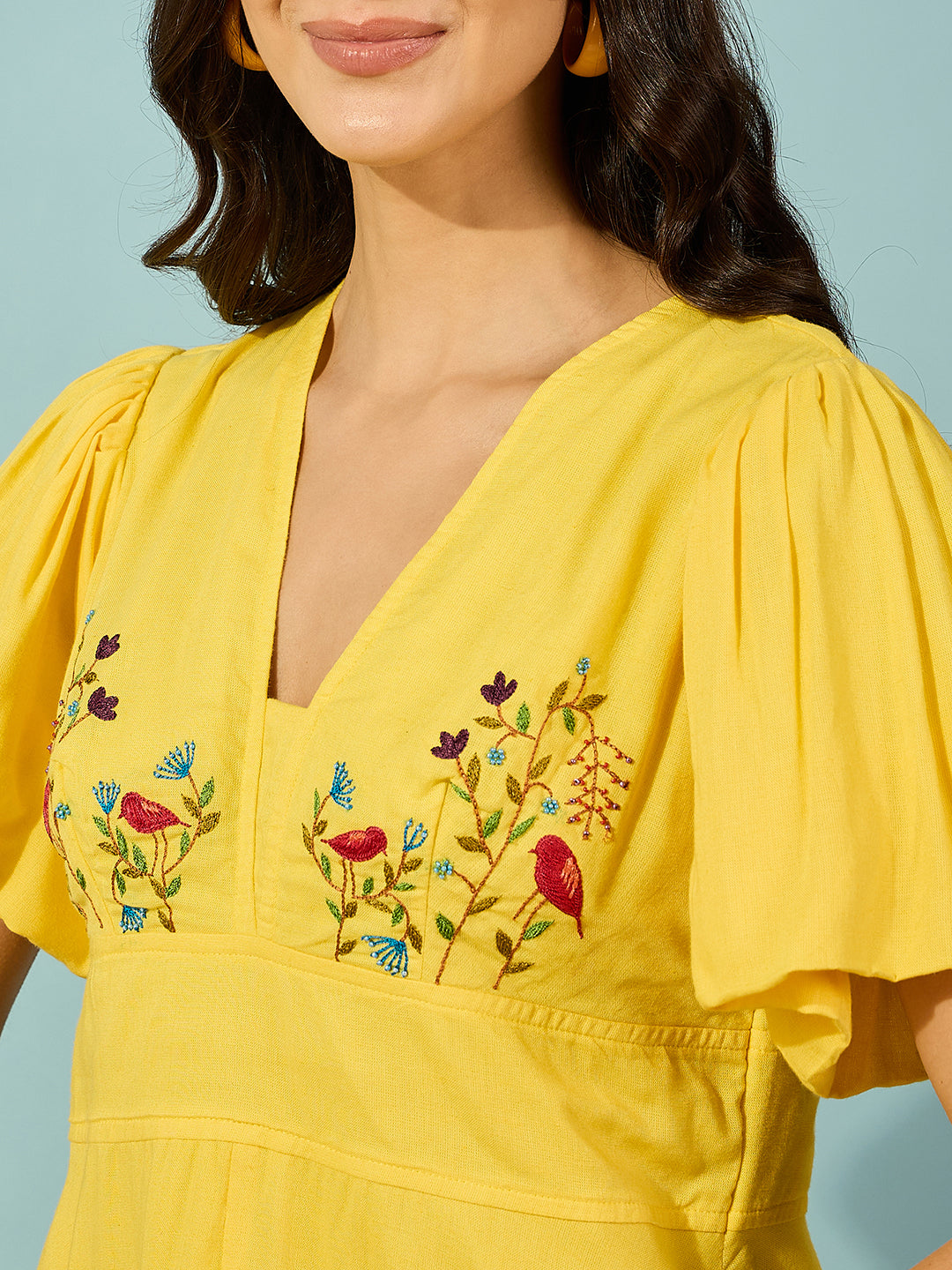 Women's knee-length yellow dress in lightweight viscose linen, adorned with exquisite hand embroidery.

