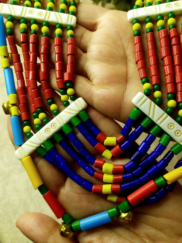 Stylish layered necklace crafted with various colorful beads and charming bell details, showcasing a unique and eye-catching design.
