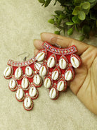 Vibrant handmade red cowry earrings featuring natural shells and intricate detailing for a bold statement.
