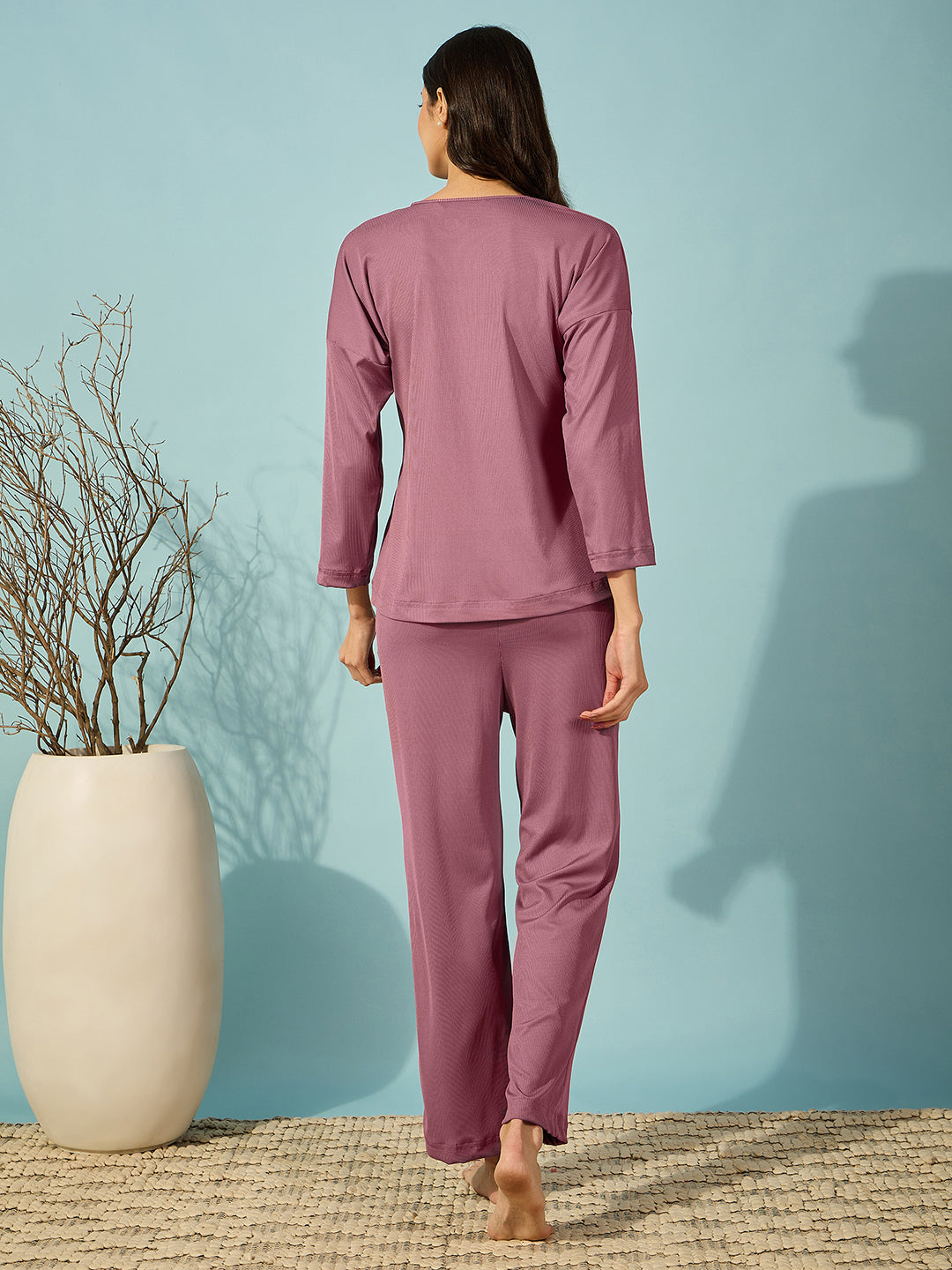 Cozy purple pyjama set with ribbed fabric, featuring full sleeves and a V-neck design.

