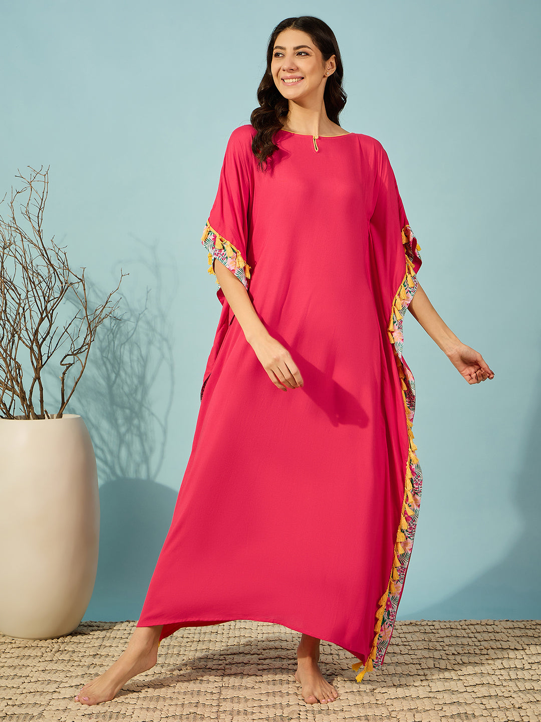 Stylish pink loungewear kaftan for women, featuring playful tassel details and floral trims.
