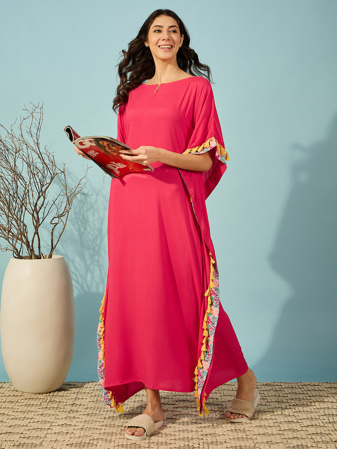 Vibrant pink rayon kaftan with fringe accents, ideal for a cozy night in.
