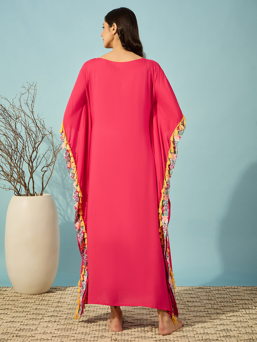 Soft pink rayon kaftan with a round neckline and playful fringe details.
