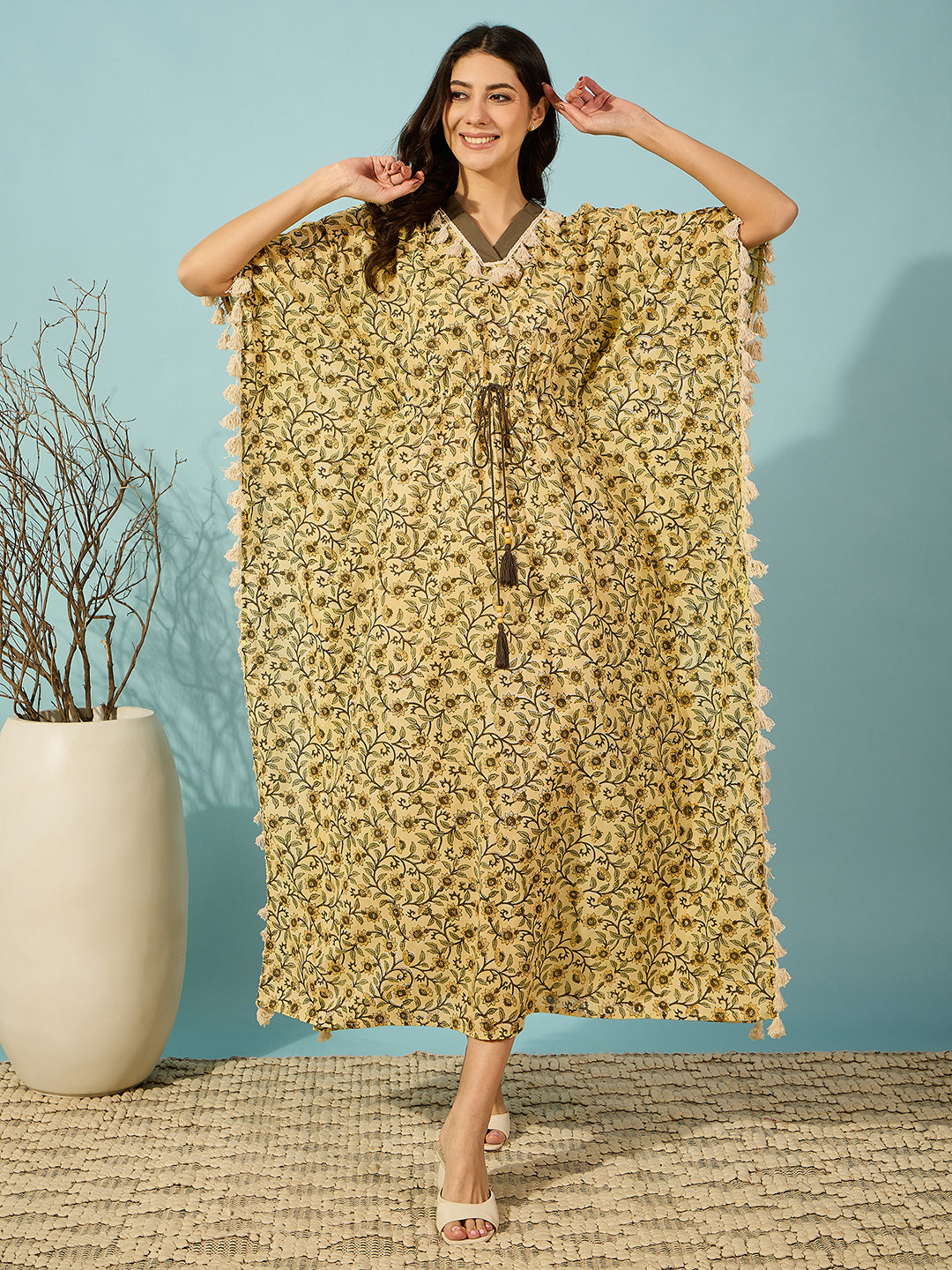 Flowy and stylish yellow kaftan for women with floral hand block print and tassel accents.
