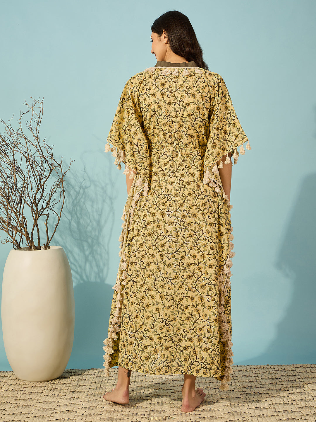 Relax in style with this yellow floral hand block printed kaftan for women, adorned with tassel details.
