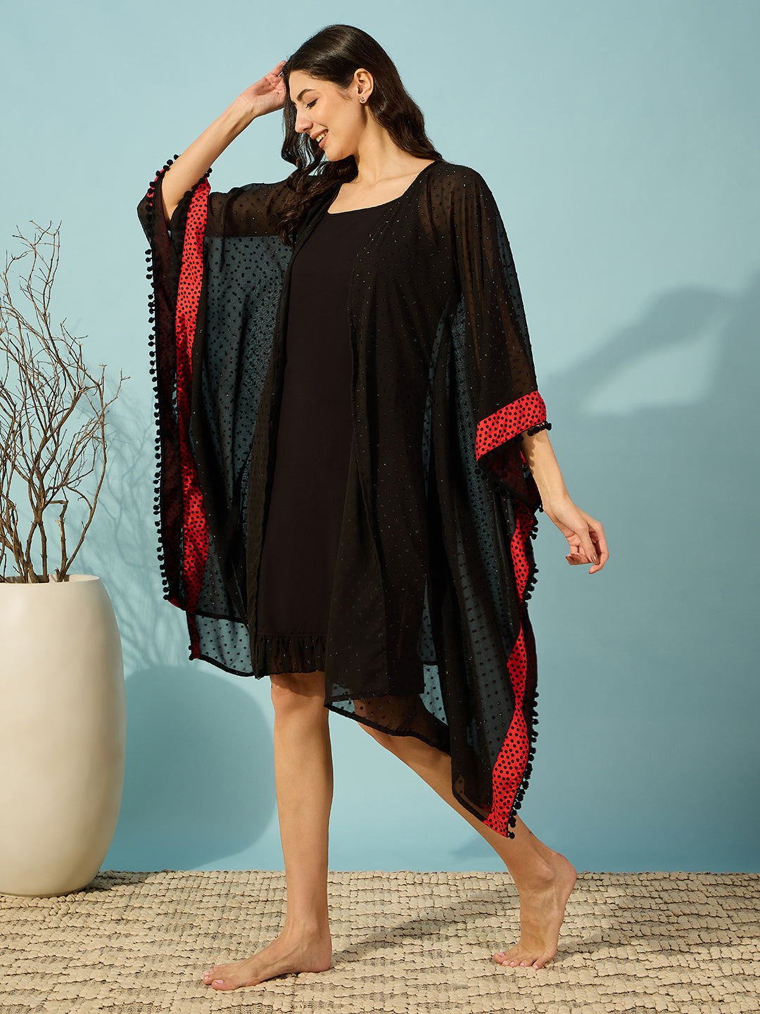 Chic black georgette gown set with black inner slip and playful red polka border and elegant lace hem ruffles.
