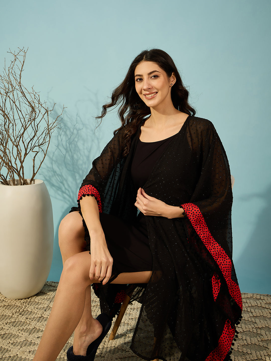 Black georgette gown with red polka border, designed for a feminine, flattering silhouette.
