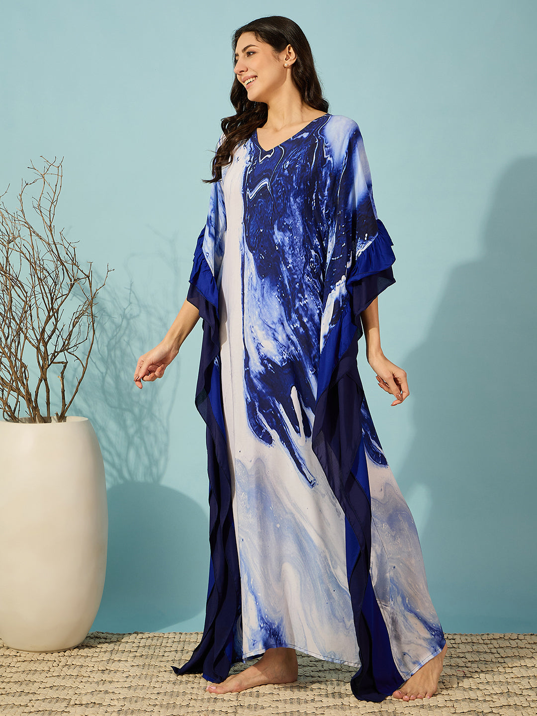 Relax in style with this soft, blue marble print kaftan featuring chic ruffles for a unique look.
