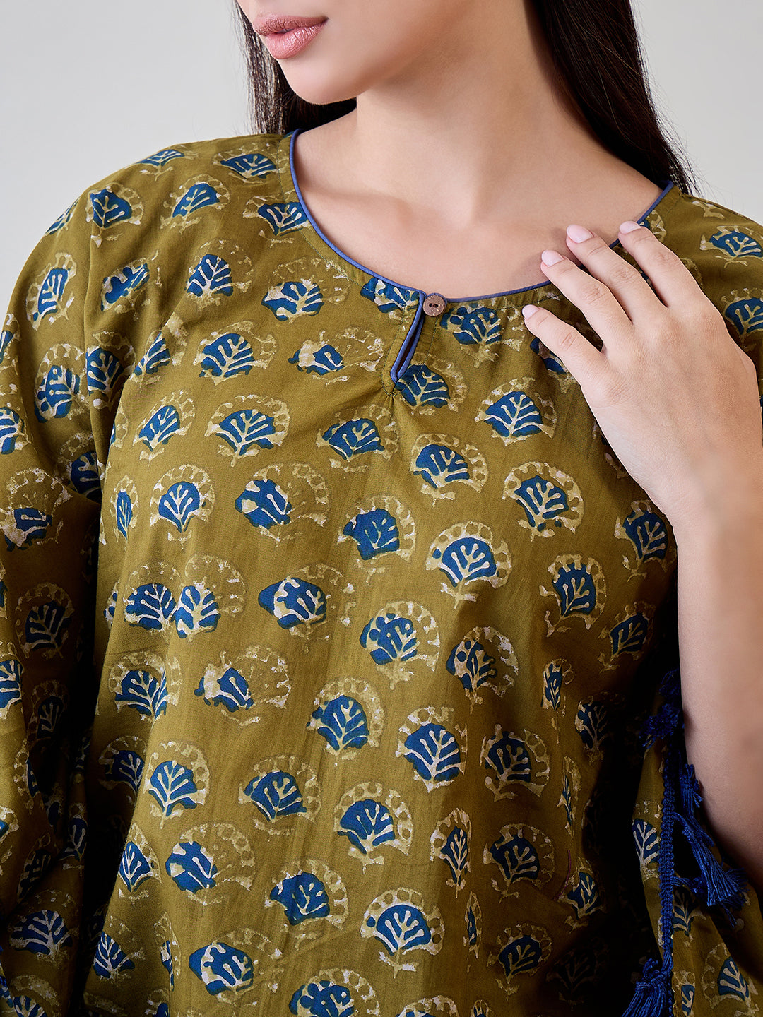 Upgrade your wardrobe with the Bright Blue Tasseled Green Cotton Kaftan featuring ethnic motifs.
