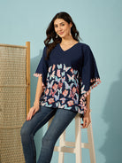 Slim-fit blue cotton kaftan top with vivid butterfly print and detailed tassel accents.
