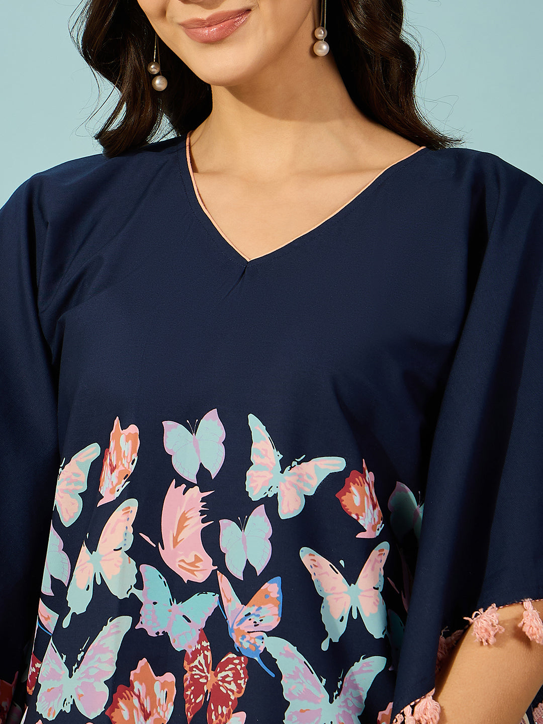 Elevate your casual style with this blue butterfly print kaftan top in soft cotton with pink tassels.
