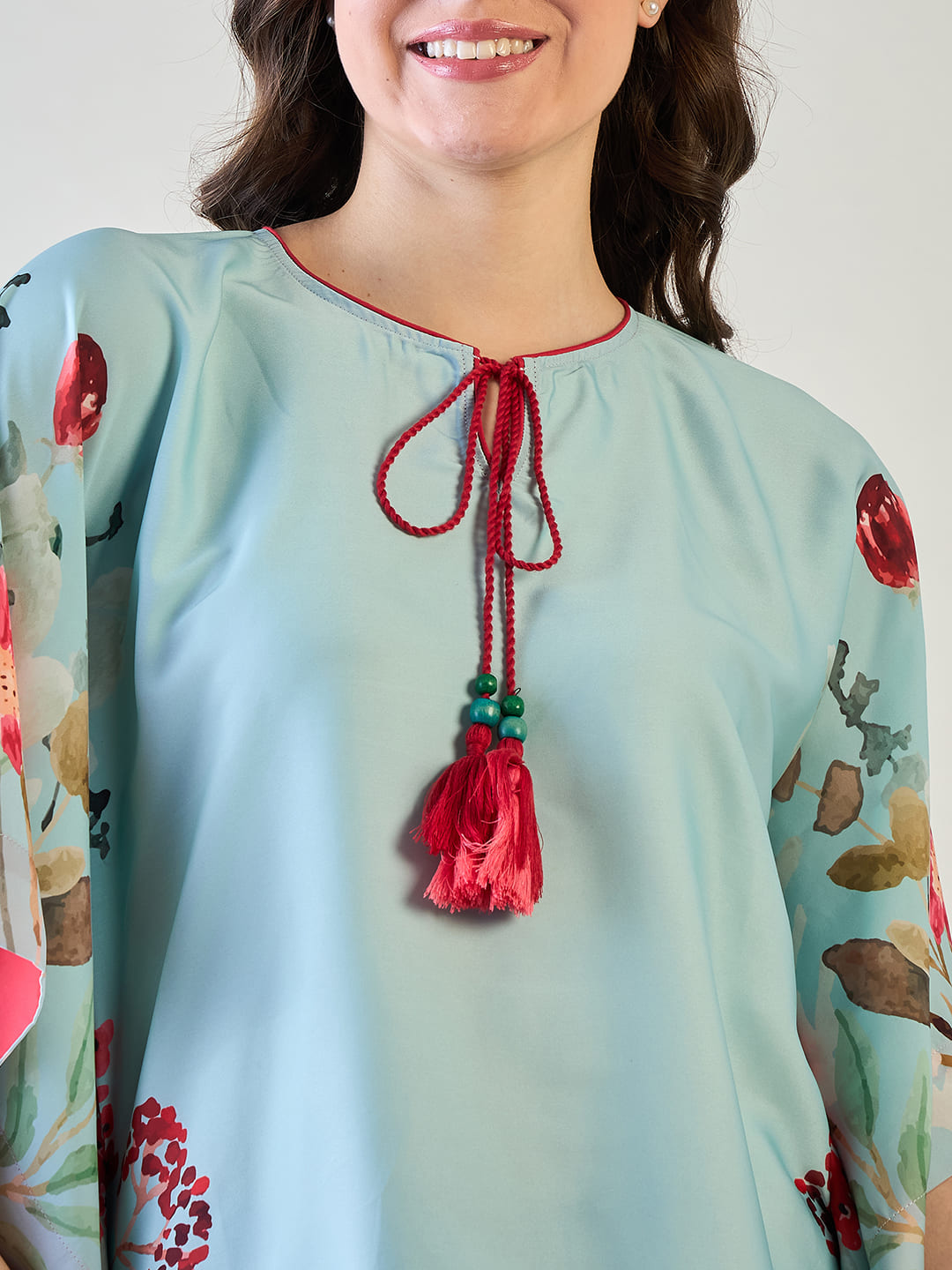 the playful tassels on the V-neck of the floral kaftan top.