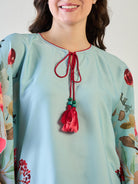 the playful tassels on the V-neck of the floral kaftan top.
