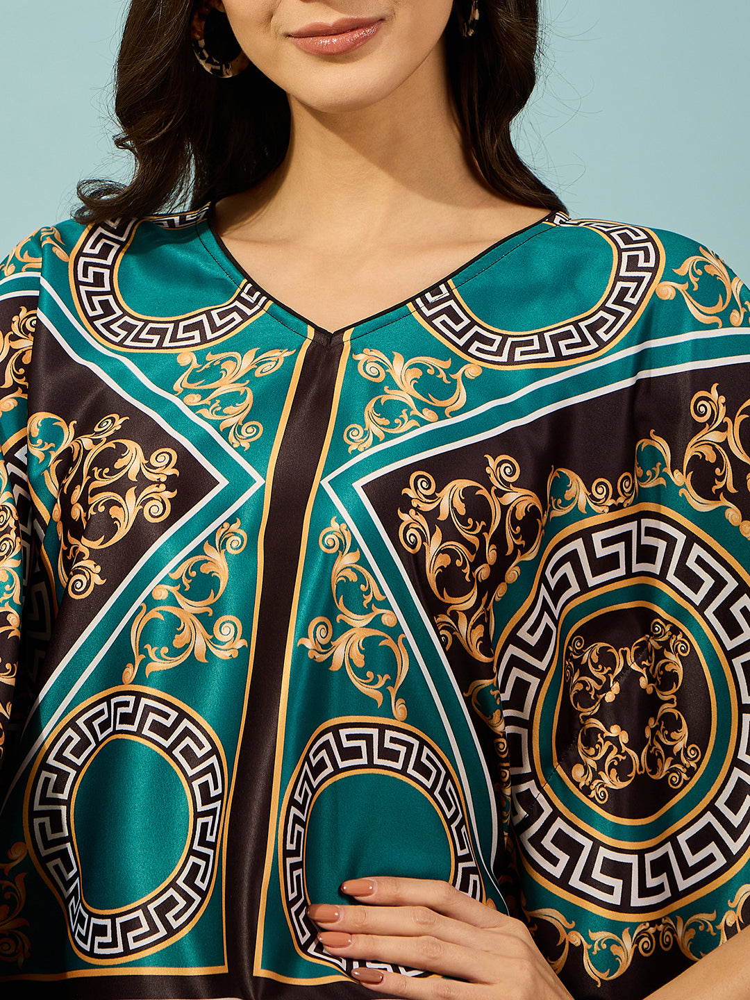 Elevate your casual wardrobe with this women's teal baroque printed kaftan-style top.
