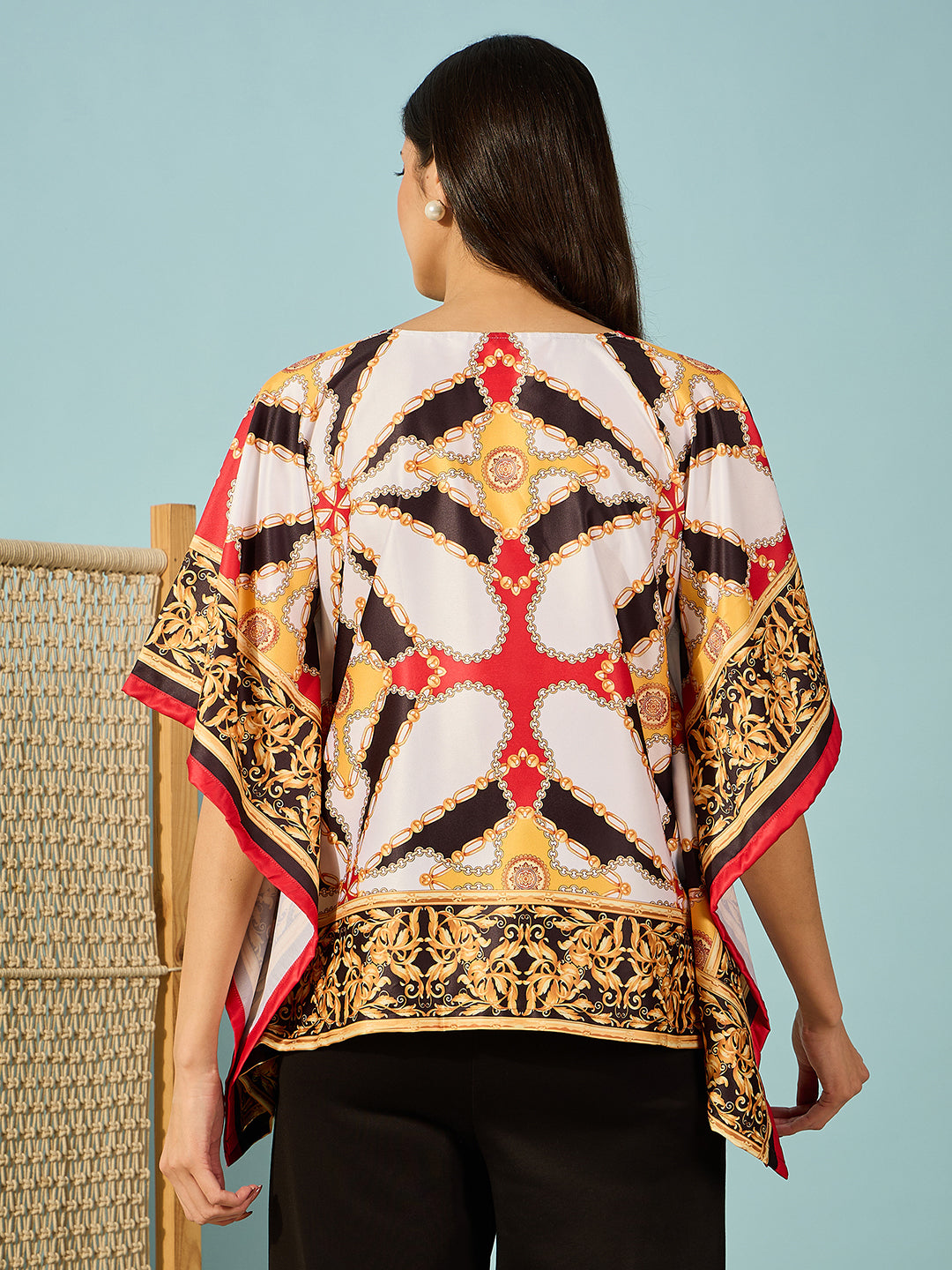 Stylish black satin kaftan top with Baroque-inspired patterns and bow tie feature for added flair.
